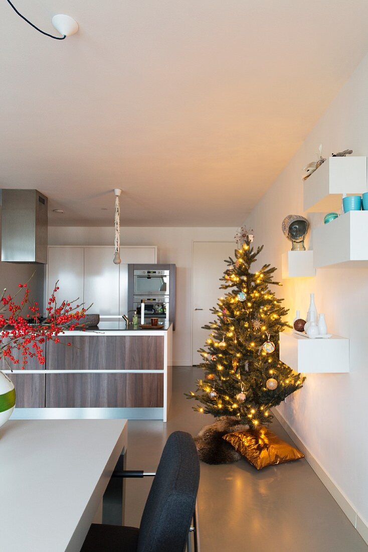 Beleuchteter Weihnachtsbaum in moderner, offener Küche