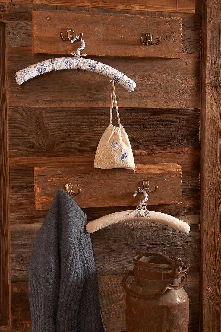 Clothes hangers covered in patterned fabric hanging from rustic coat racks