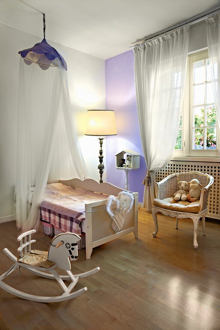 Cot under canopy, Rococo-style armchair and rocking chair in nursery