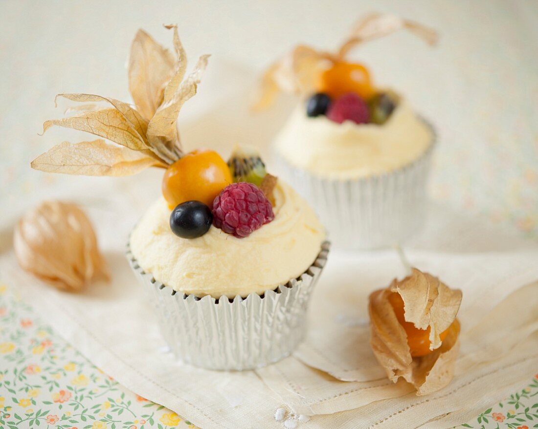 Cupcakes with blueberries, kiwis, raspberries and physalis