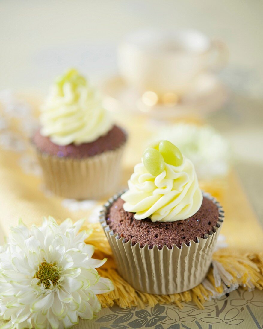 Chocolate cupcakes with vanilla frosting and green apple bonbons