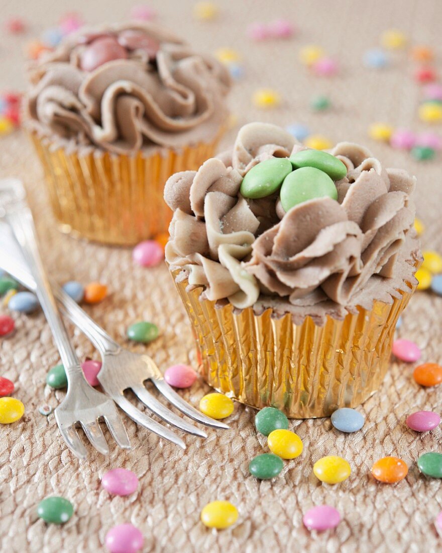 Cupcakes mit Schokoladencreme und bunten Schokolinsen
