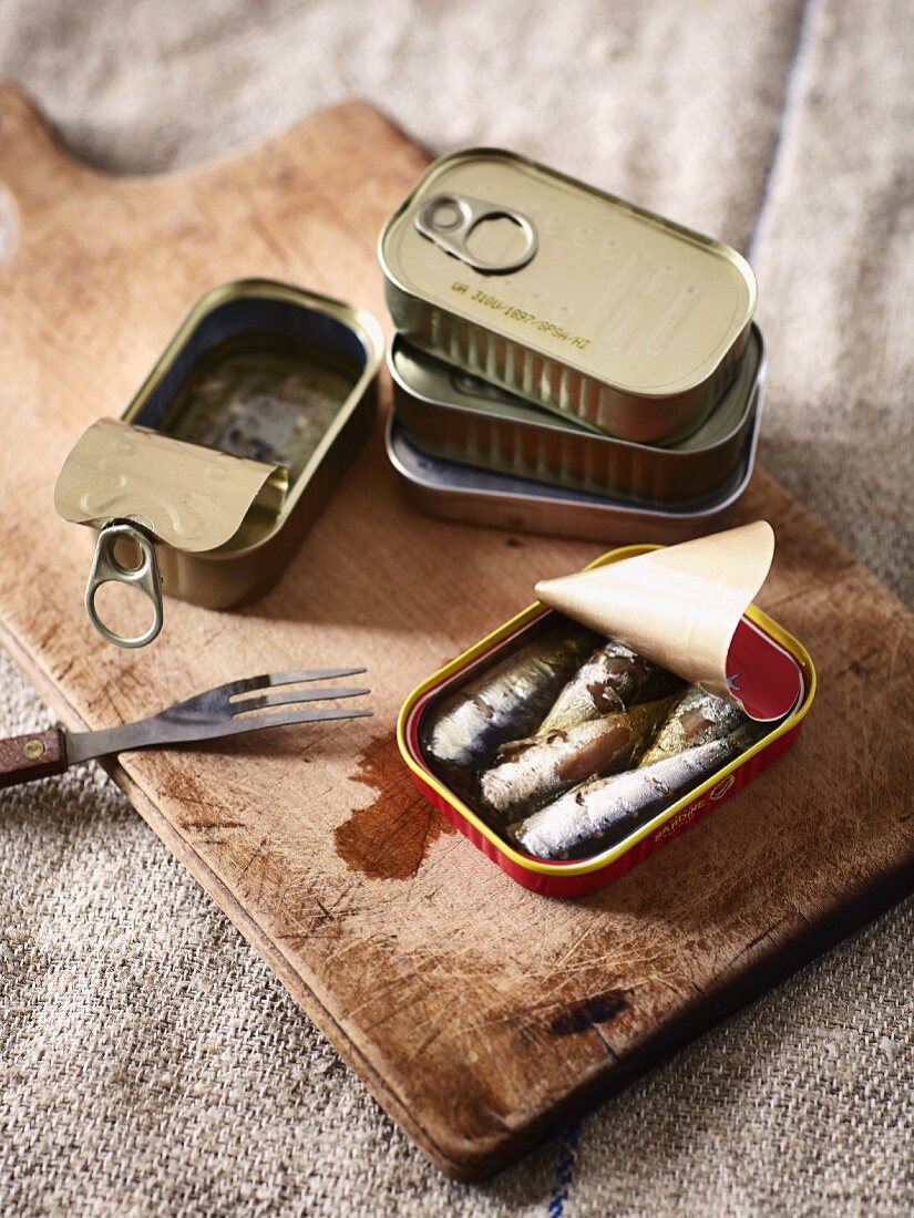 Sardines in oil on a chopping board