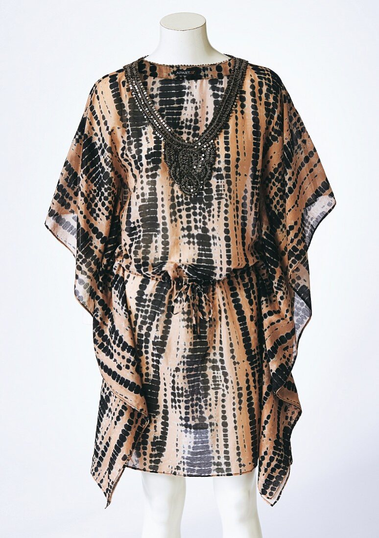 A hippie-style, black and brown tunic on a tailor's dummy