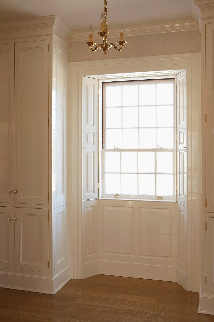 Bay window with elegant, panelled cladding and fitted cupboard