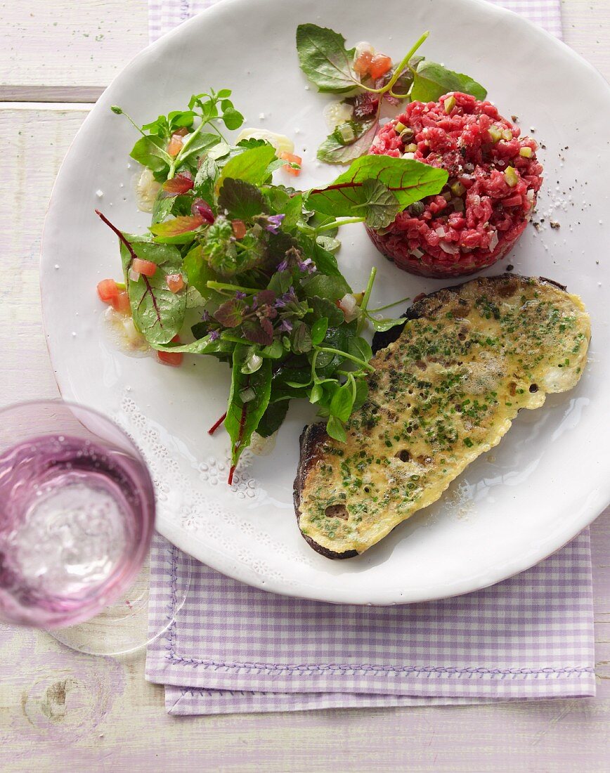 French toast made from country bread with beef tatar and wild herb salad