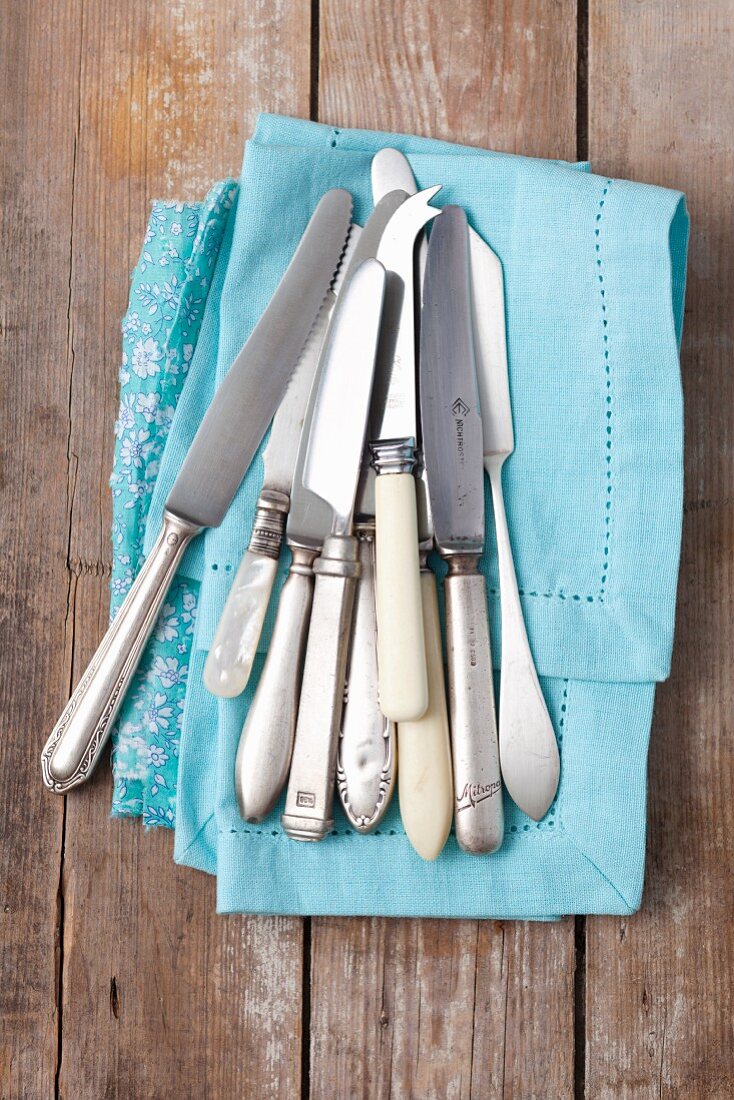 Various old knives on a fabric napkin