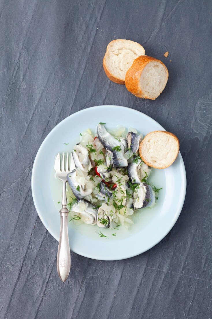 Vinegar marinated herring with onions and dill