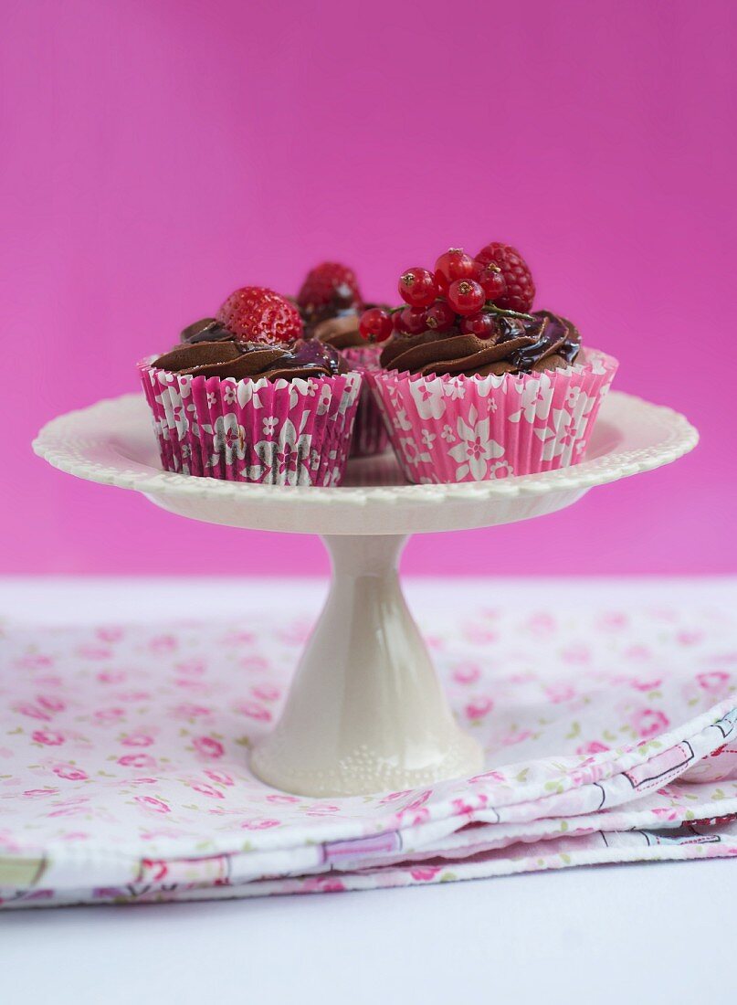 Chocolate cupcakes with chocolate glaze and fresh berries