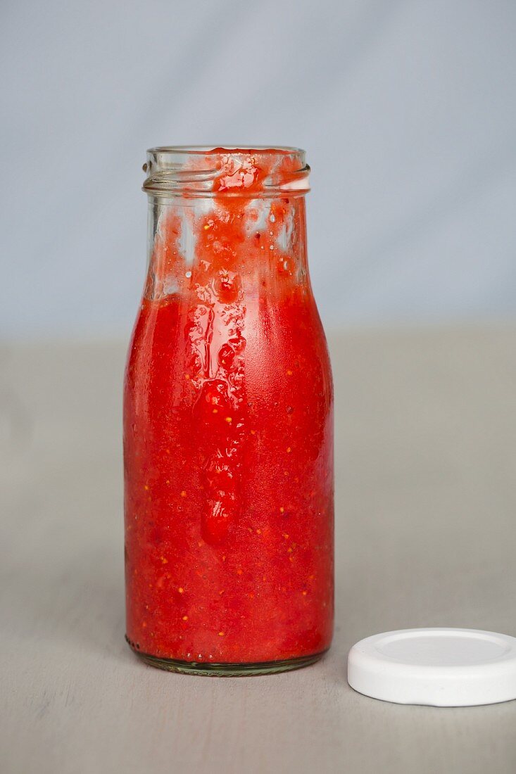 Eine Flasche Erdbeersauce mit Deckel