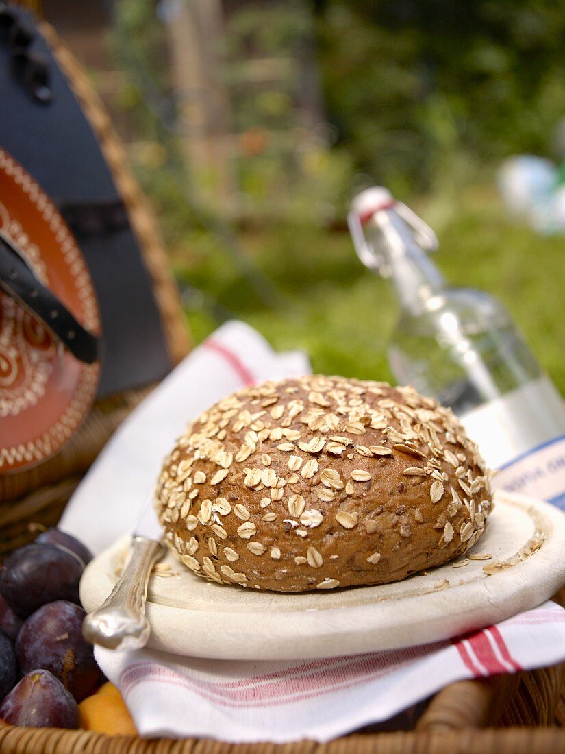 Wholemeal bread with oats on a wooden plate in a garden