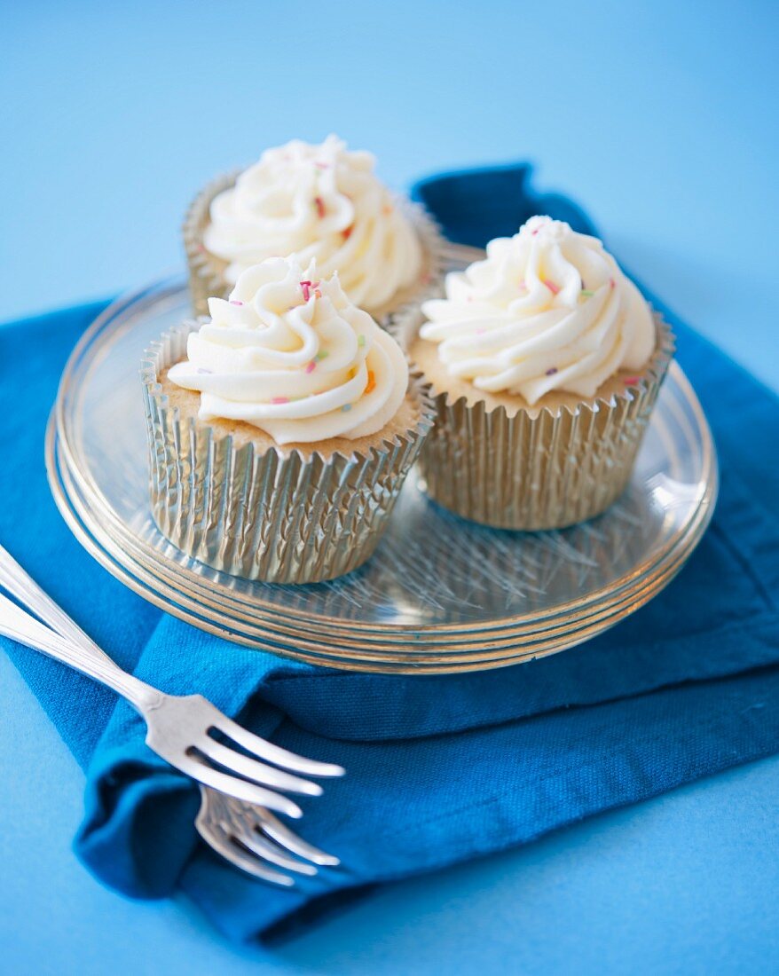 White chocolate cream cupcakes decorated with sugar sprinkles