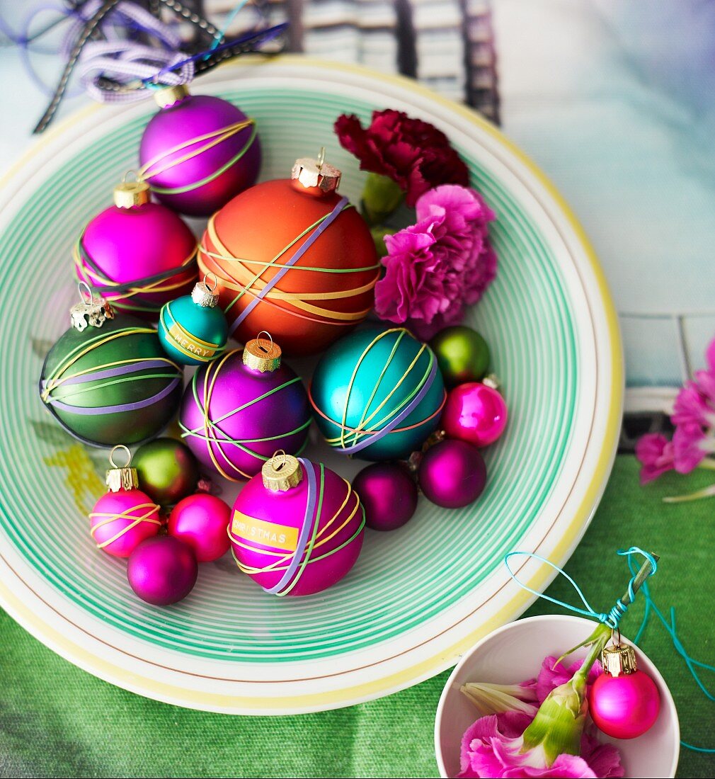Christmas tree baubles wrapped with colourful rubber bands decorating table