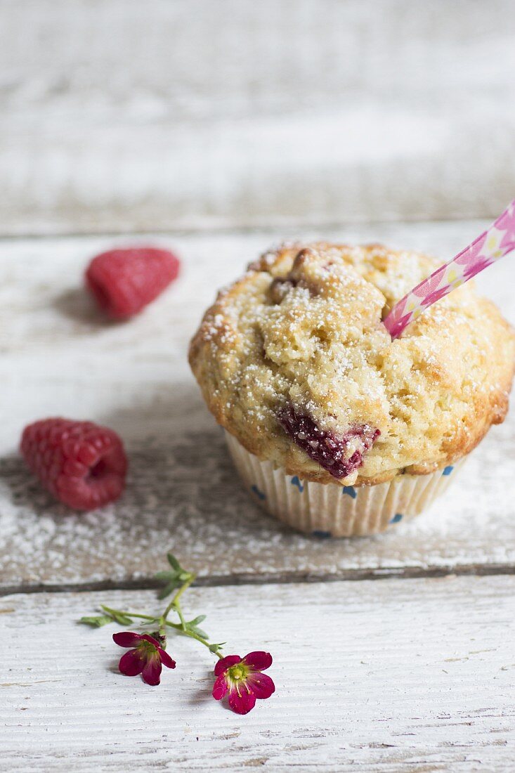 Raspberry muffins with fresh raspberries and small pink flowers