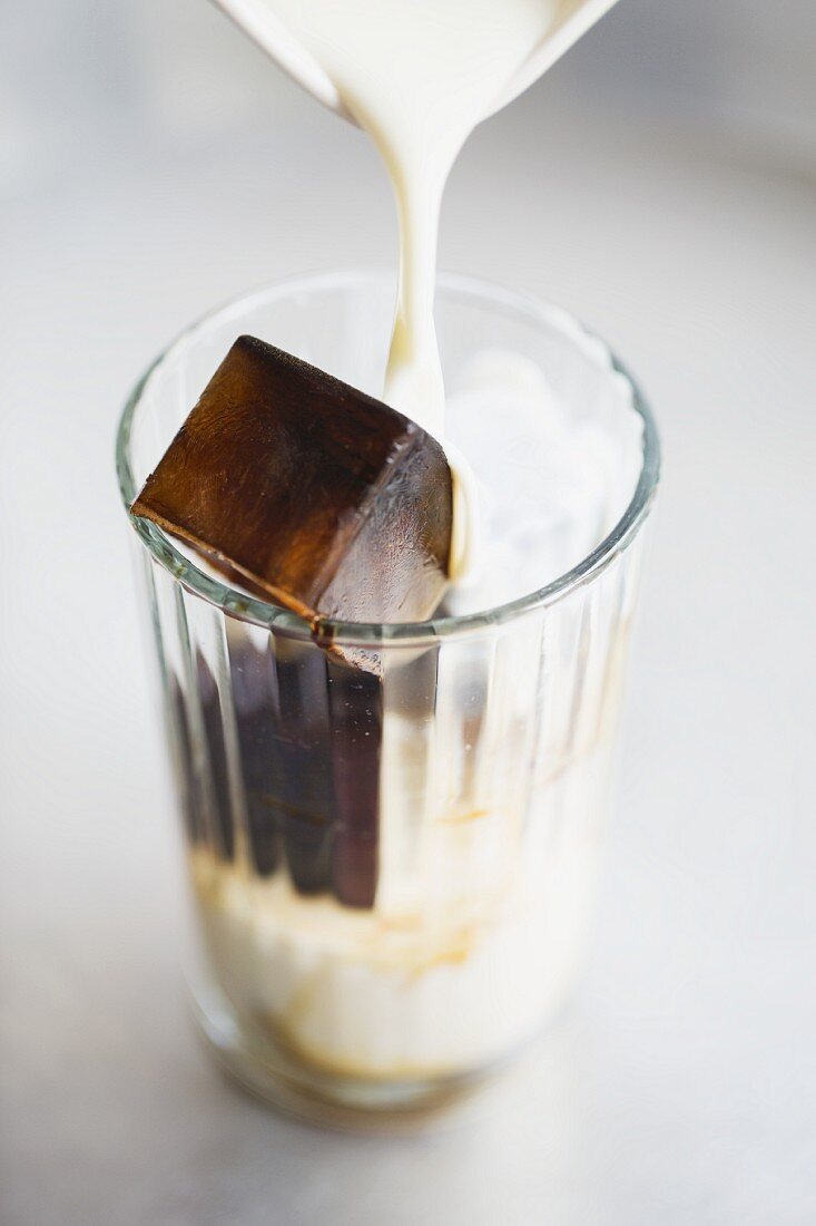 Glas mit Espressoeiswürfel und Milch