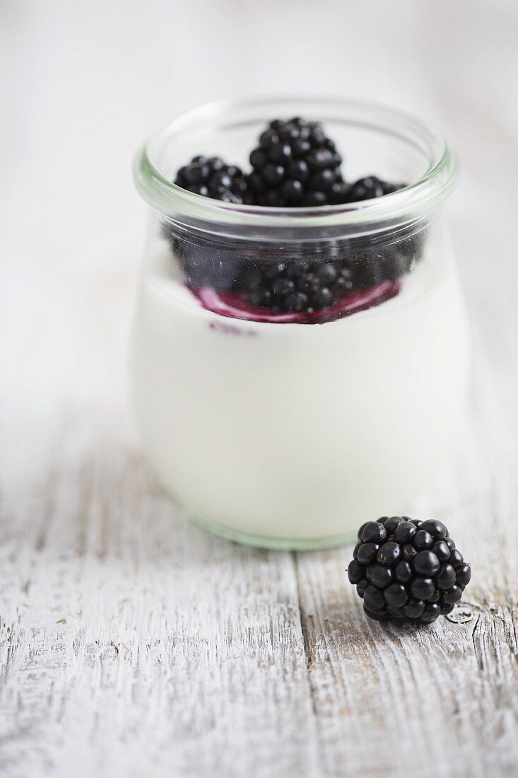 Joghurt mit Brombeeren in kleinem Glas