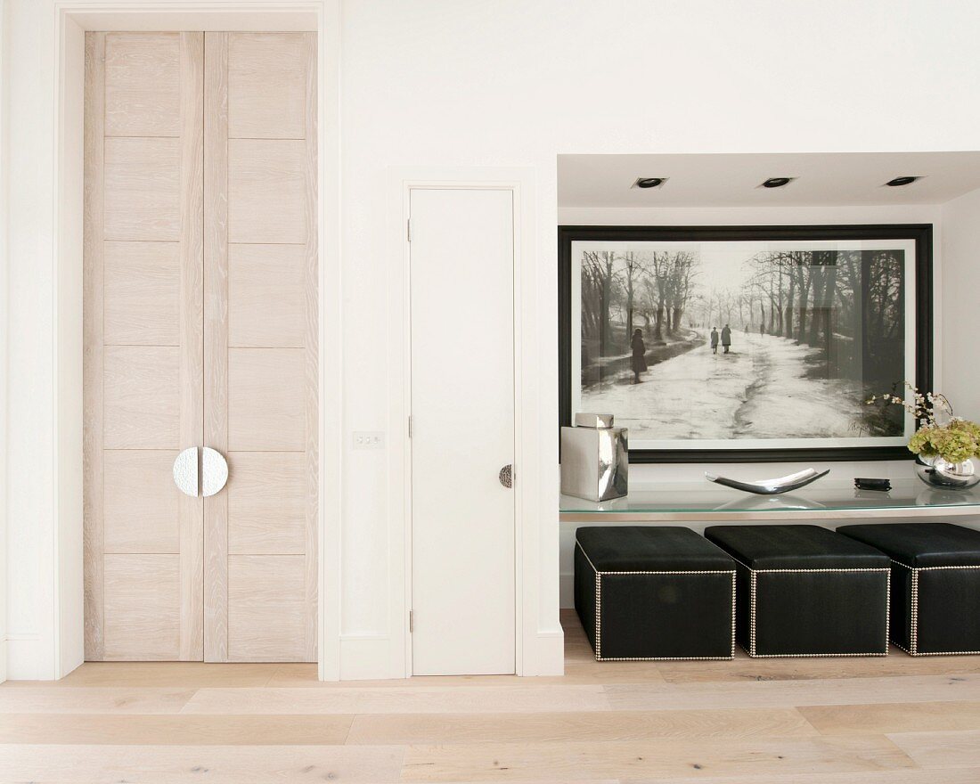 Oriental double doors, picture and pouffes in niche in minimalist foyer