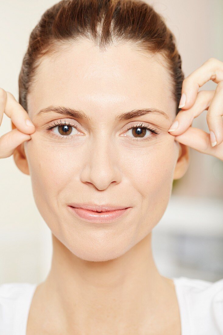 A brunette woman having an eye massage