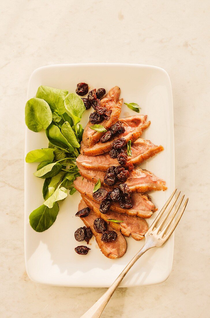 Sliced pan-fried duck breast with a cherry and basil relish