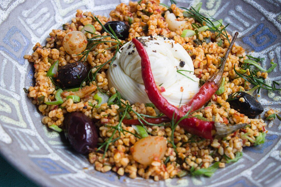Bulgur salad with mozzarella, olives, chilli peppers and herbs