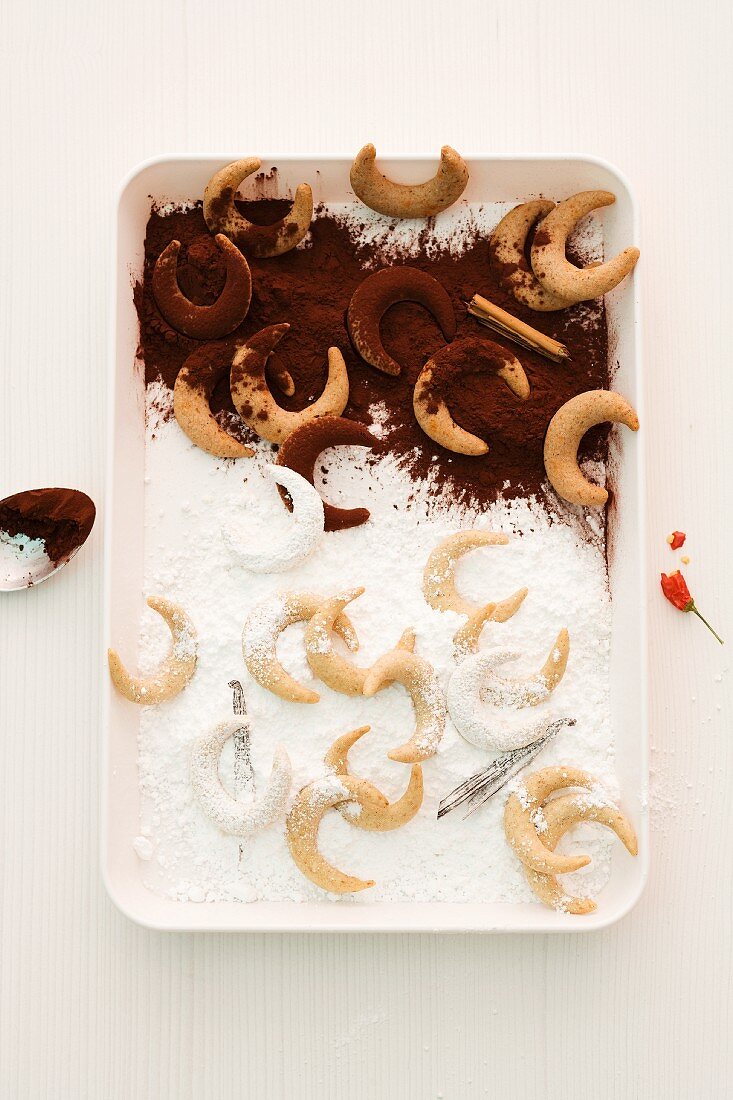 Vanilla crescent biscuits with icing sugar and cocoa powder (seen from above)