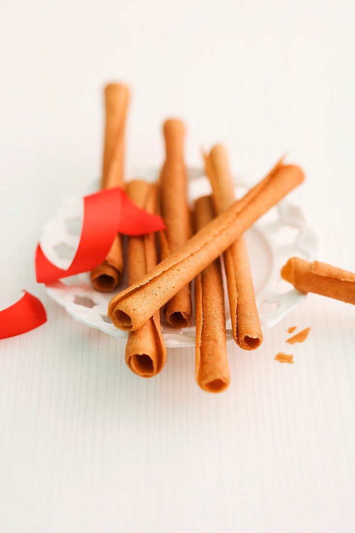 Cinnamon sticks and a red ribbon on a plate