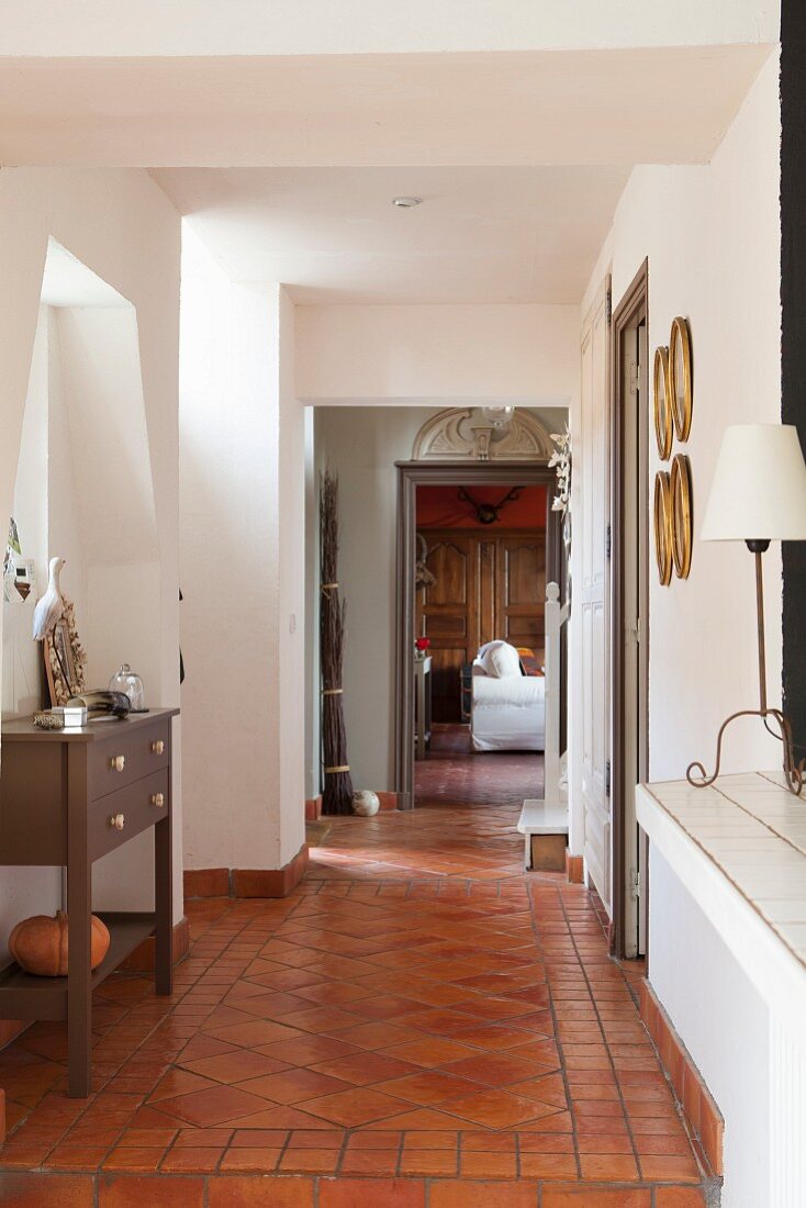 Rustic hallway with terracotta floor tiles and white walls