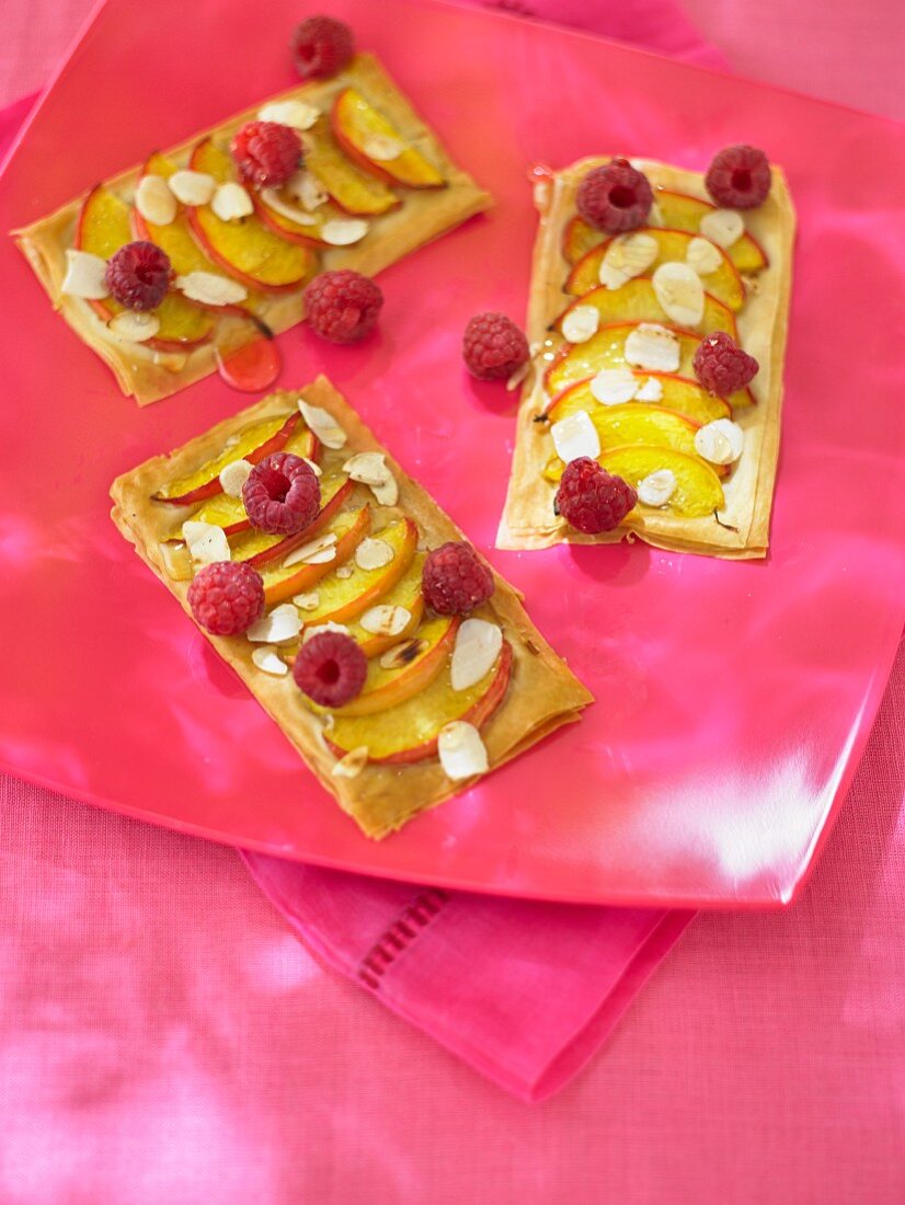 Puff pastries with peaches and raspberries