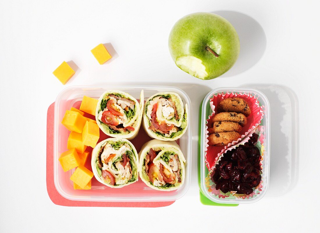 Wraps, fruit and biscuits in a lunch box