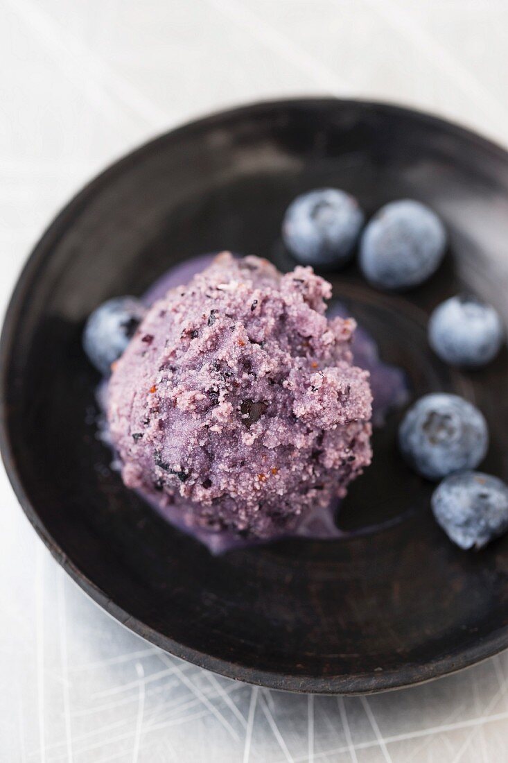 A scoop of homemade blueberry ice cream on a plate