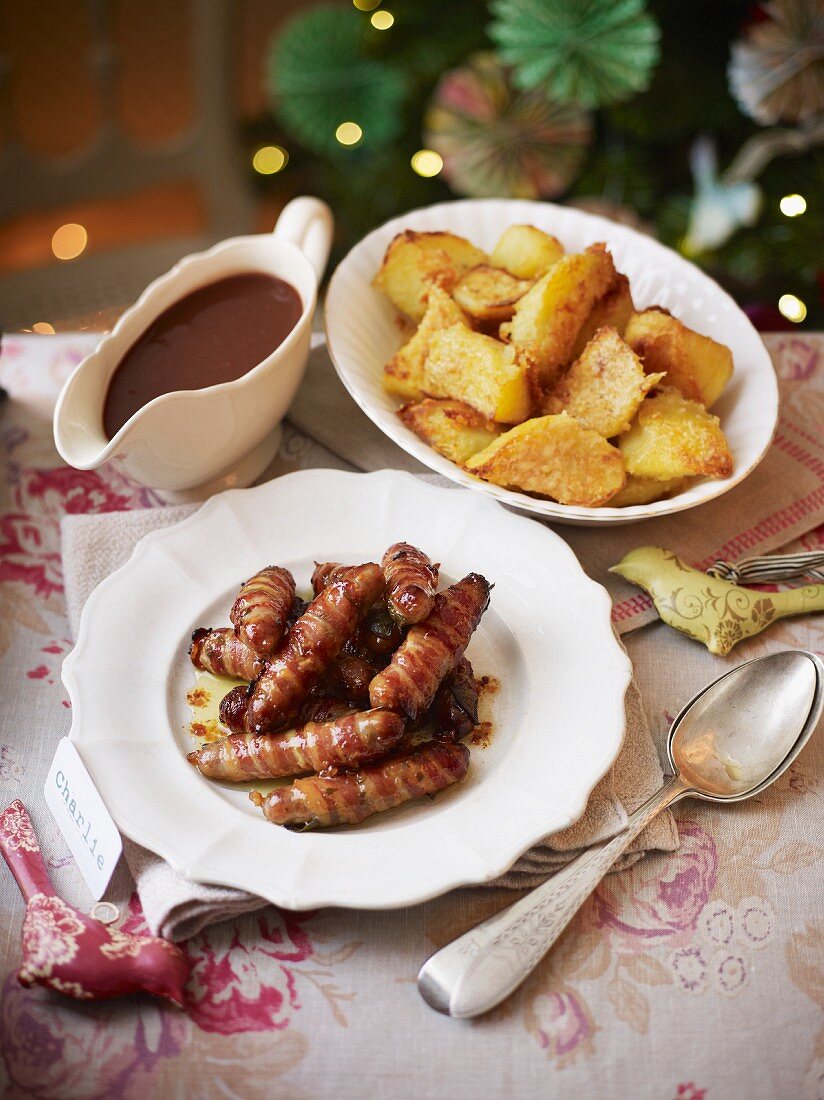 Bratwürstchen im Speckmantel mit Bratkartoffeln und Bratensauce