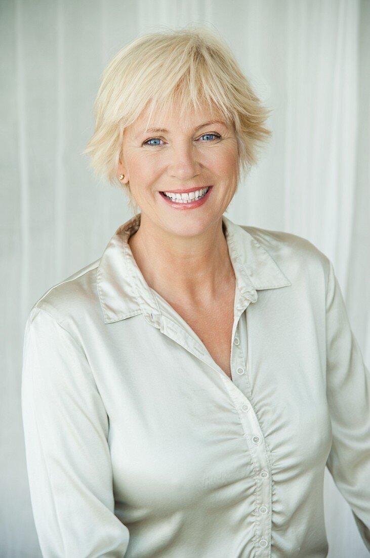 An older woman wearing a silver-coloured blouse