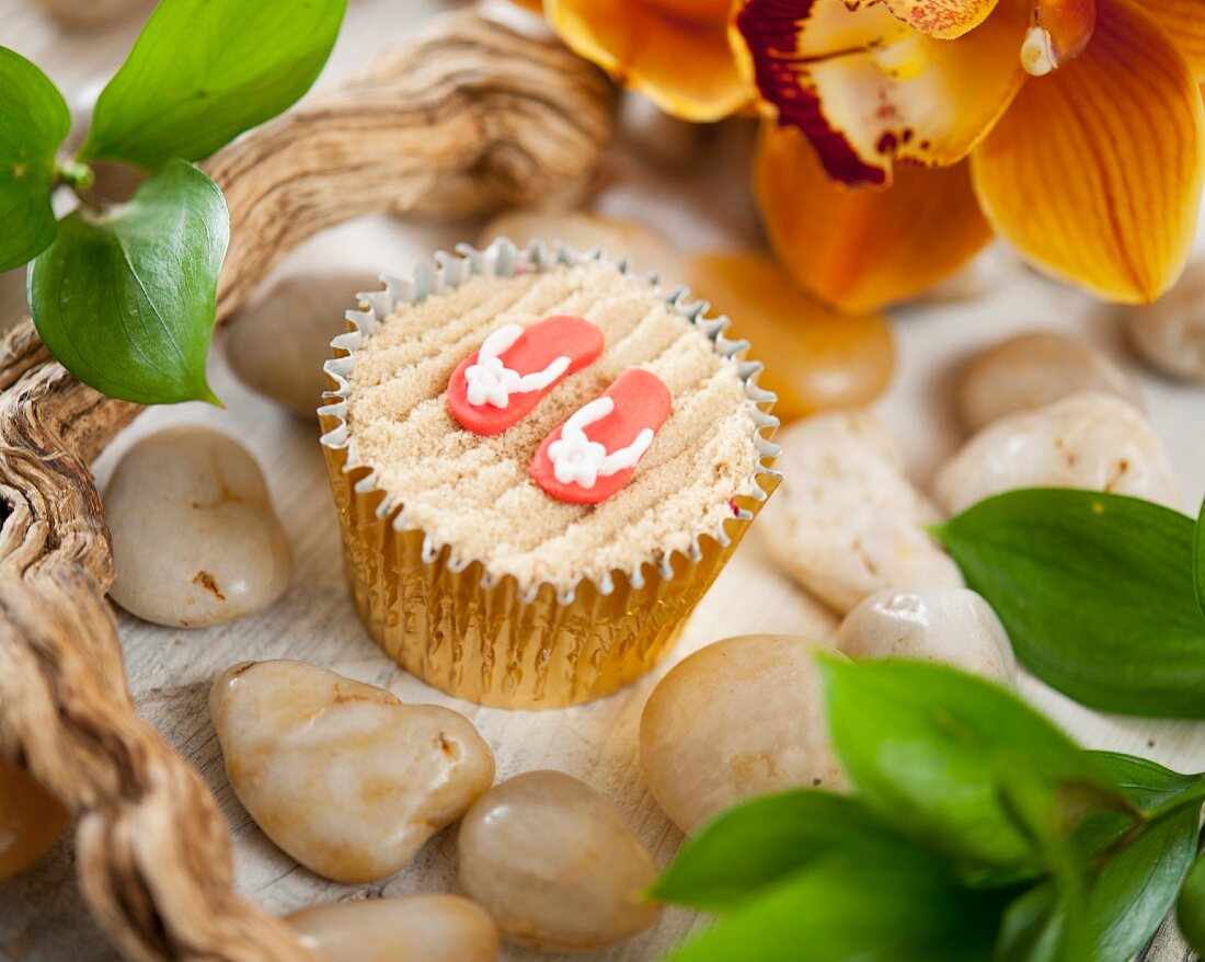 A beach cupcake decorated with flip-flops