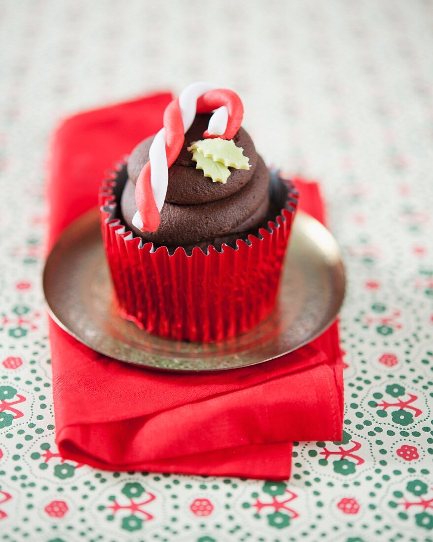 A chocolate cupcake decorated with a candy cane