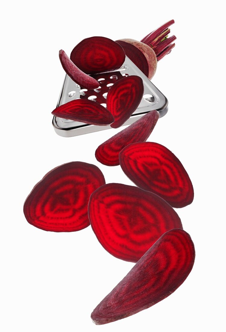 A grater with a beetroot and beetroot slices