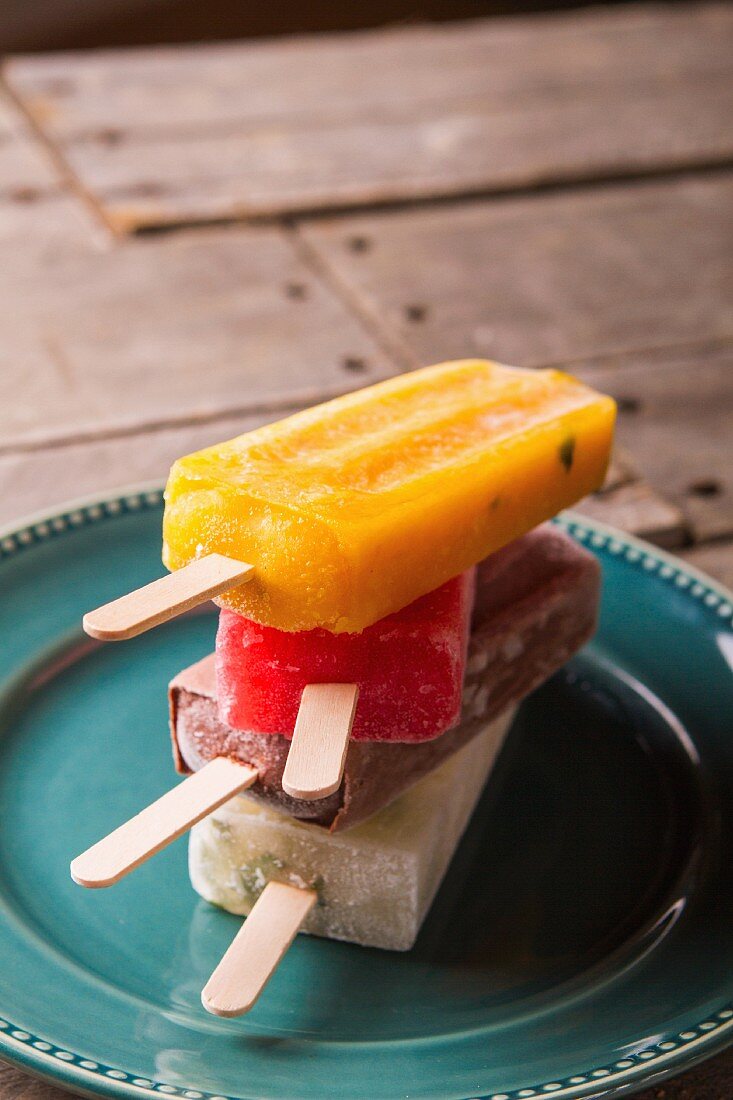 Four ice lollies on a plate