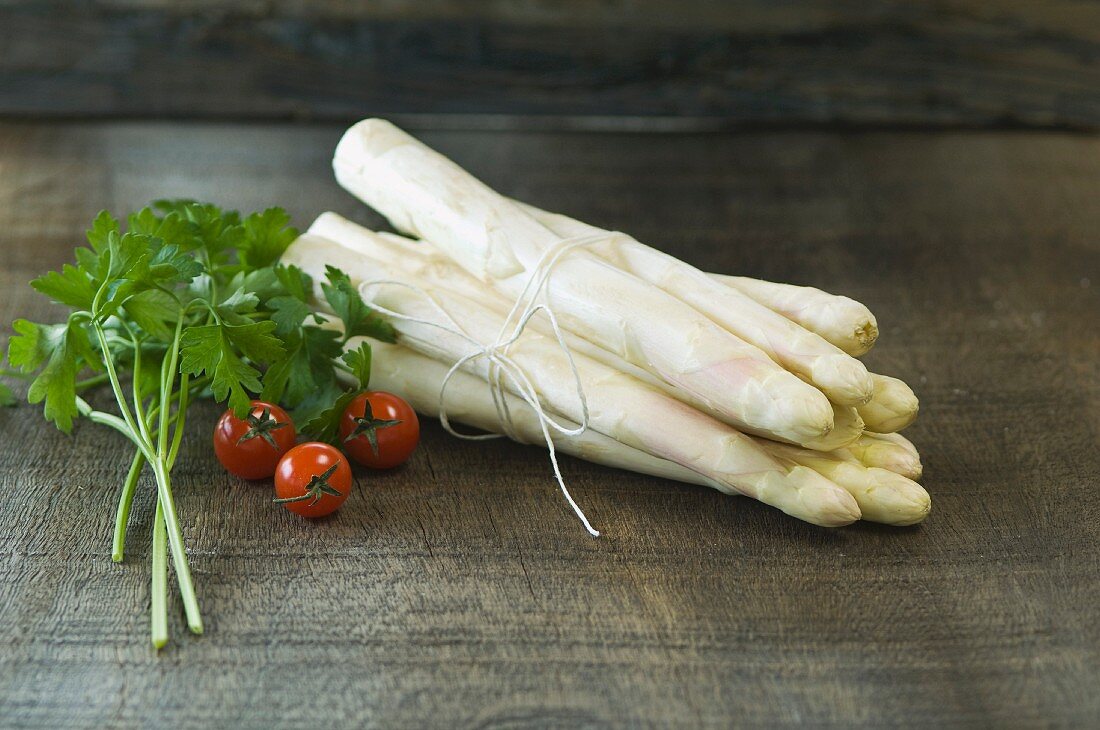 A bundle of fresh white asparagus on a wooden table