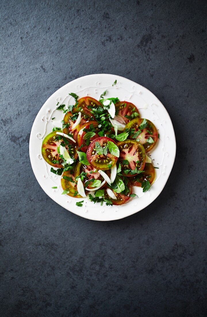 Tomato salad with black tomatoes, shallots and herbs (seen from above)