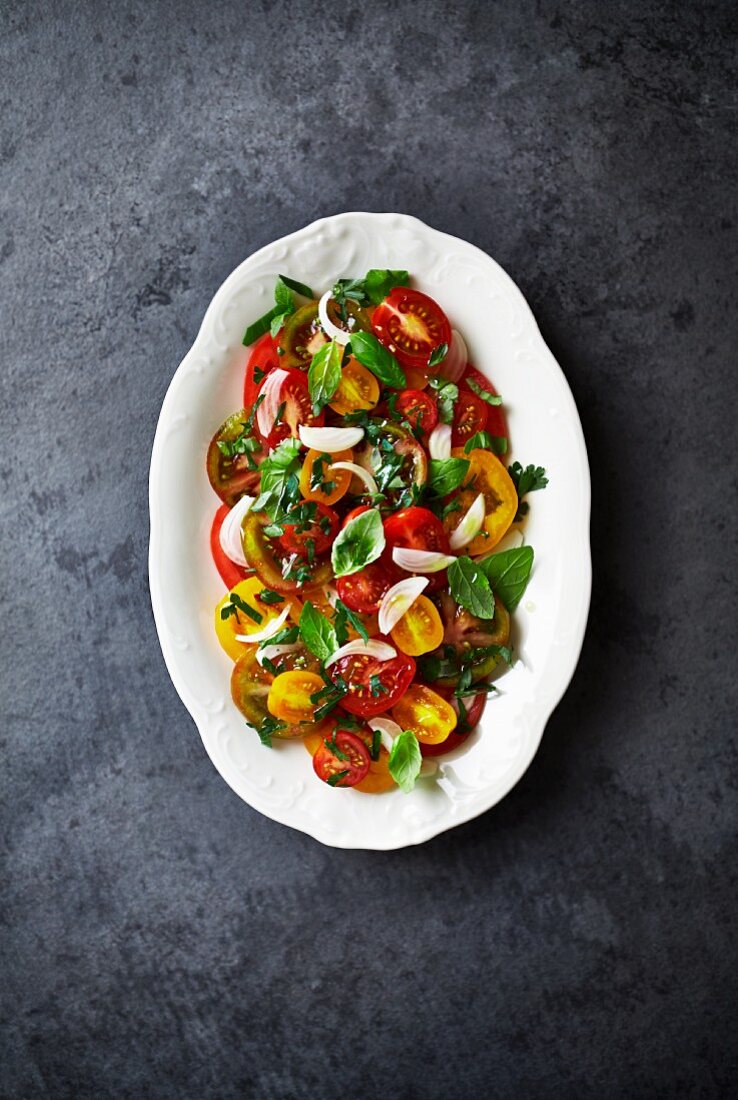 Tomato salad with red and yellow tomatoes, shallots and herbs (seen from above)