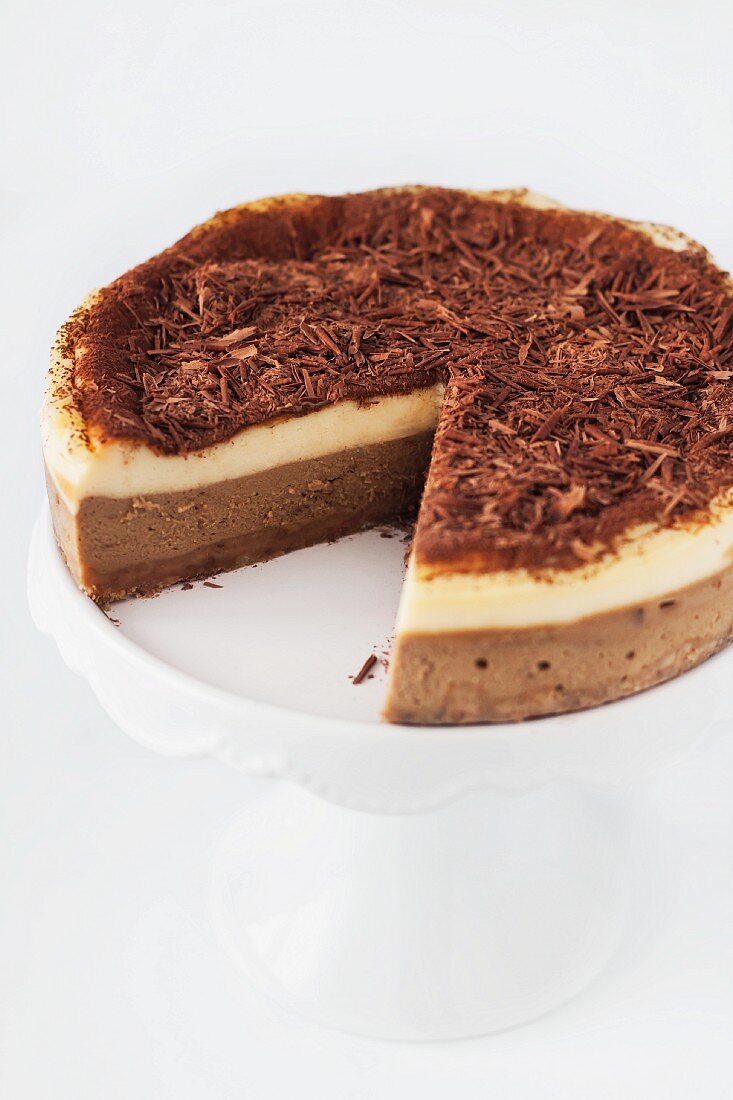 Angeschnittener Tiramisu-Käsekuchen auf Tortenständer