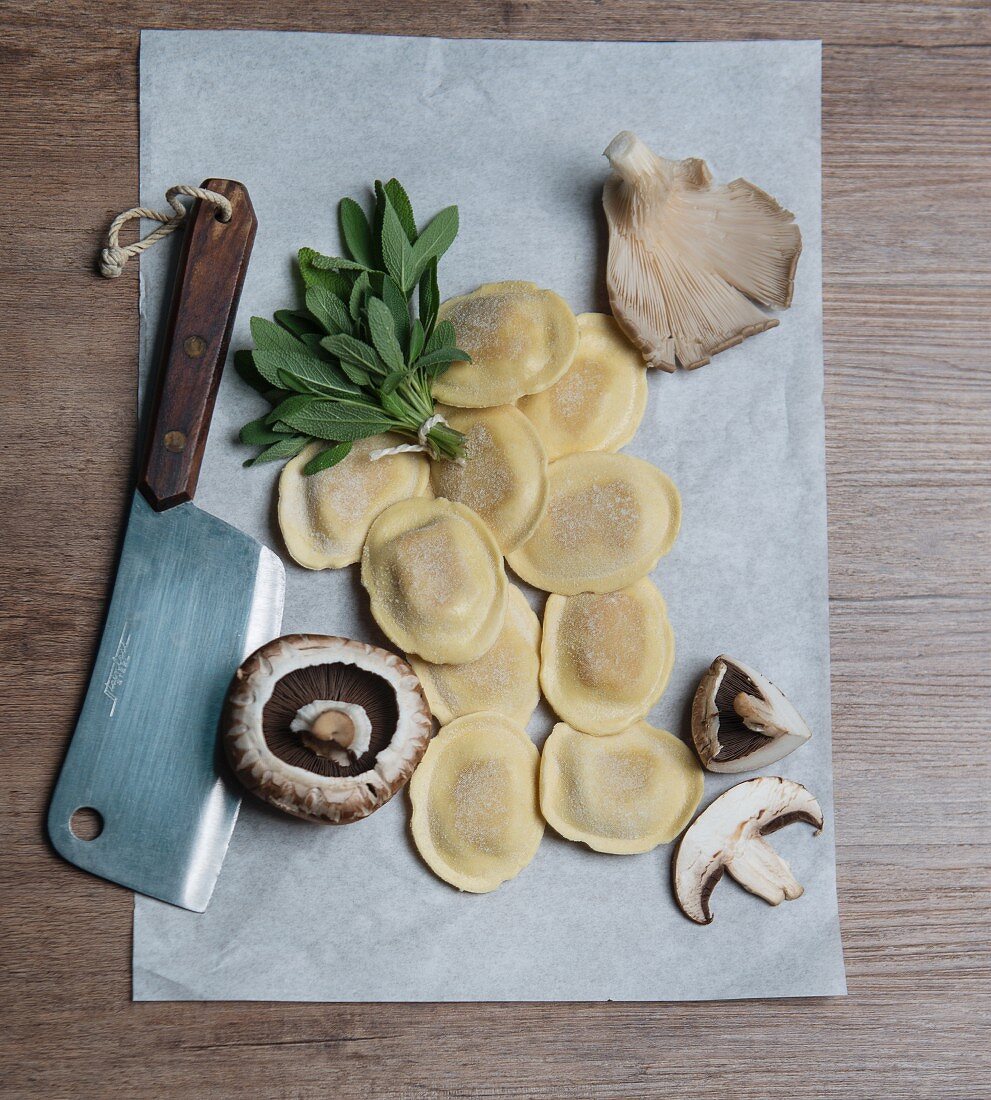 An arrangement of ingredients with ravioli, sage and mushrooms