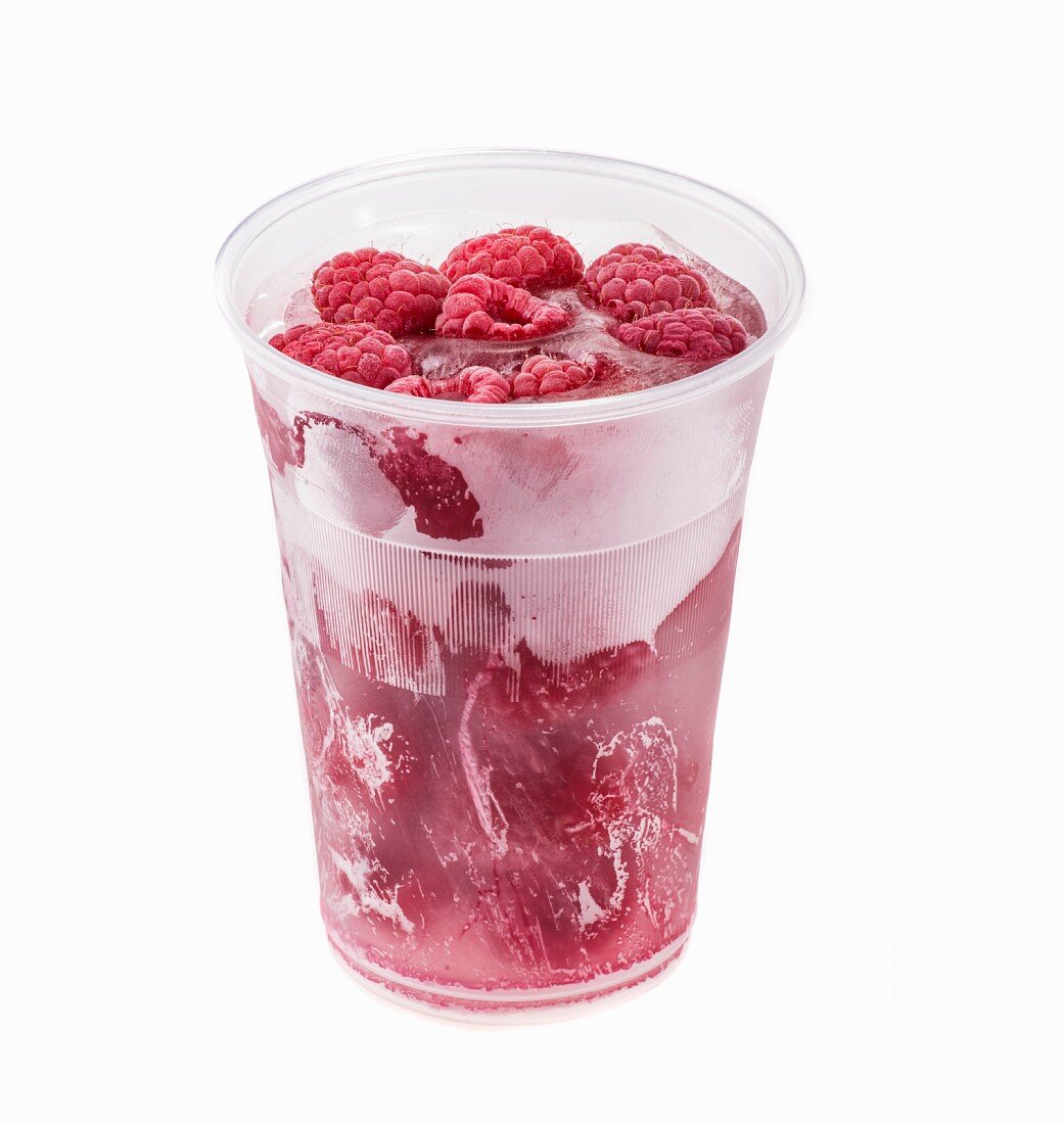 Frozen raspberries in a plastic cup