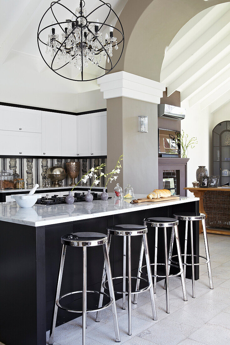 Kitchen with large island and bar stools and modern chandelier