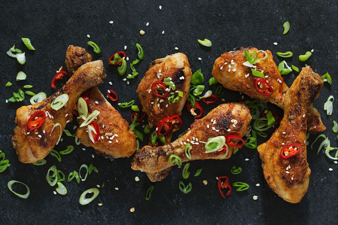 Chicken drumsticks with chilli and spring onions (seen from above)