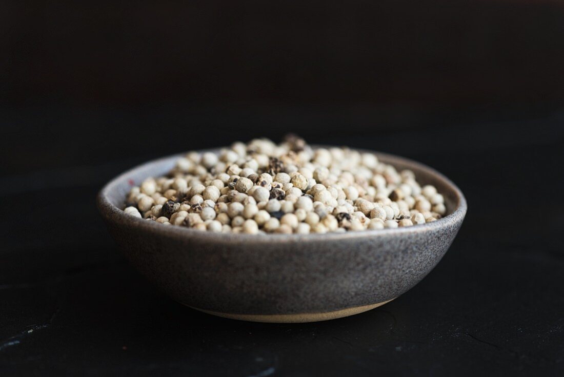 A bowl of white peppercorns