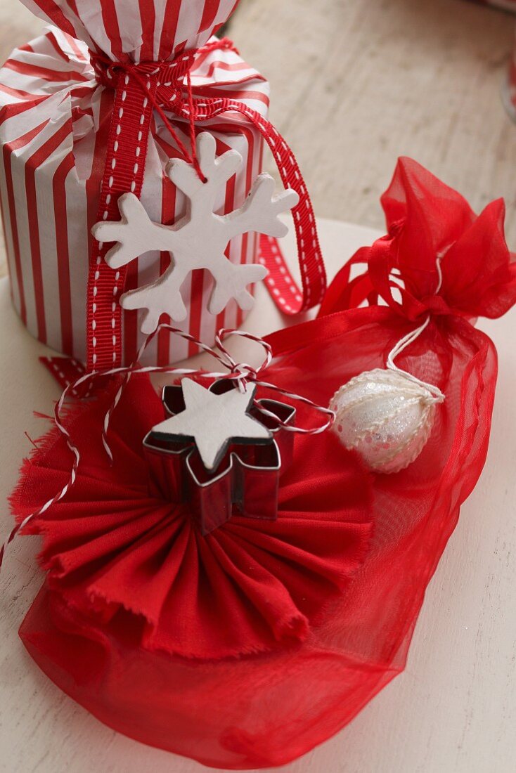Rot-weiss verpacktes Weihnachtsgeschenk mit selbstgebastelten Geschenkanhängern