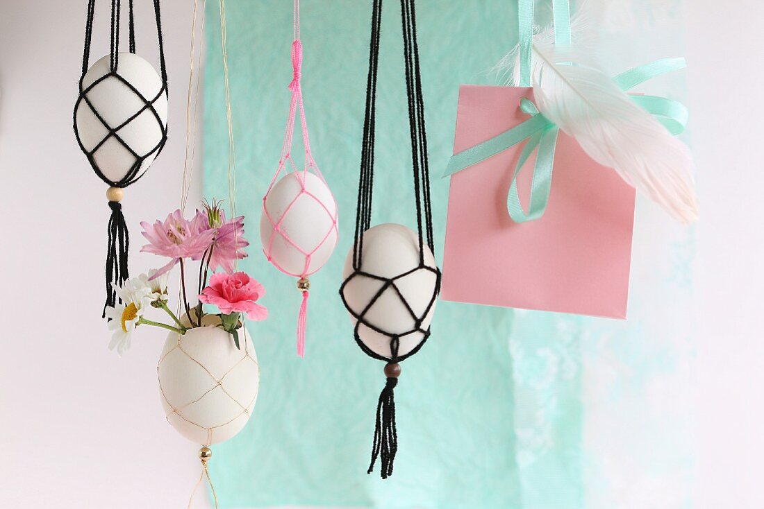 Romantic arrangement of flowers and Easter eggs in various macrame holders