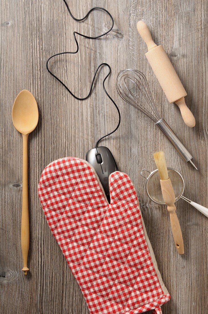 Kitchen utensils and a computer mouse on a wooden surface