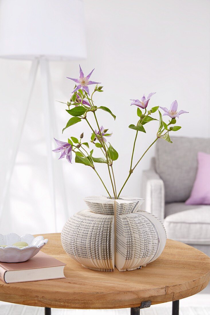 A homemade flower vase made from a test tube and an old book