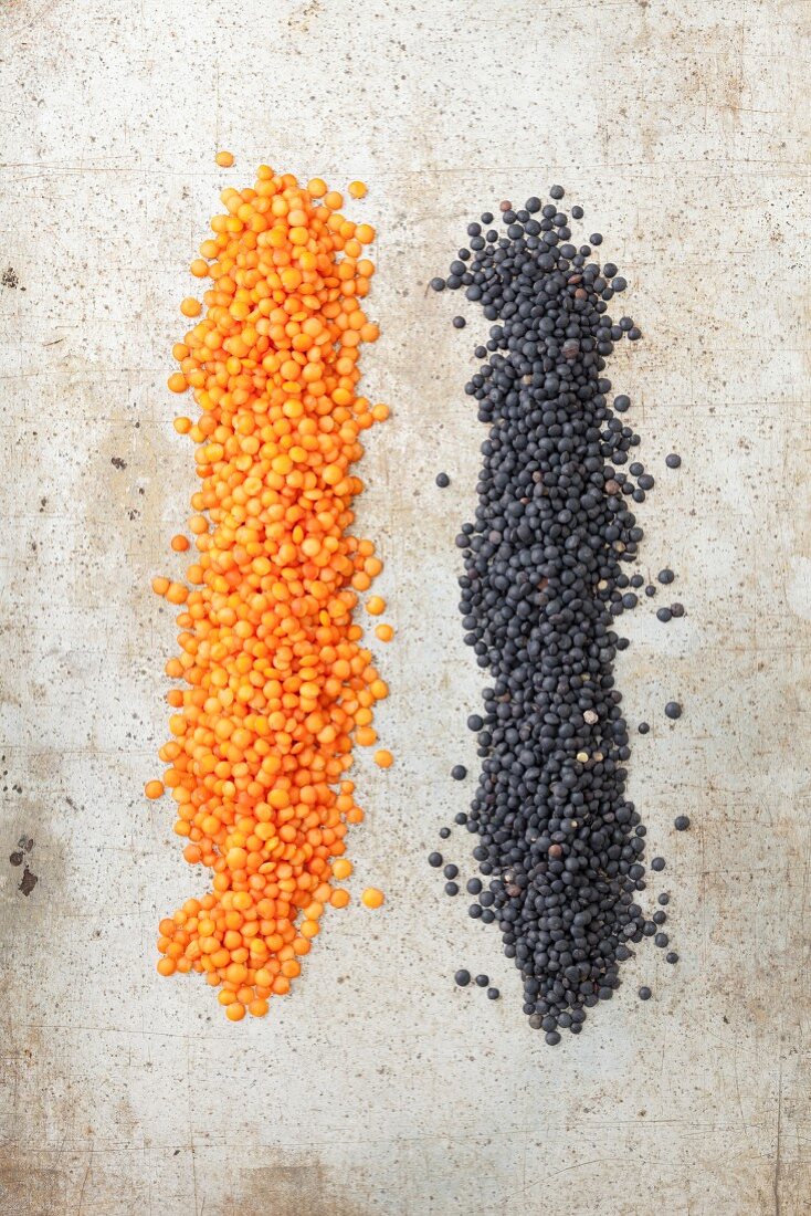 Red and black lentils on a stone surface